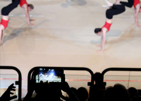 viewer photographs with a cell phone some girls performing an exercise during a gym classの写真素材