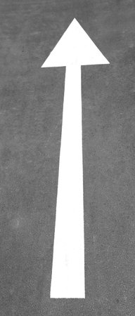 big white arrow on the black road