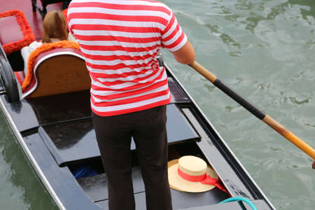 gondolier with t-shirt red and white on the gondola in Venice Italyの写真素材