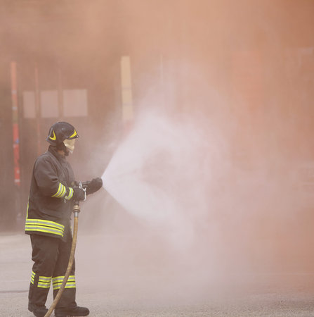 Italia, IT, Italy - May 10, 2018: Italian firefighter uses the hydrant with foam during a practice...