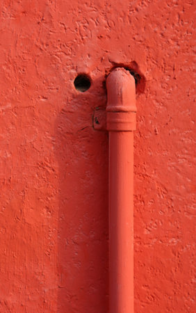 red piping for methane gas that enters the wall of a dwelling