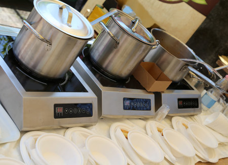 three big pots in the kitchen with plastic dishes