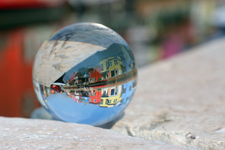 large glass sphere with the image of the colorful houses of Burano Island near Venice in Italy