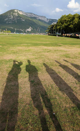 Shadows of a family of five persons in the public parkの写真素材