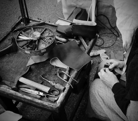 ancient workshop with expert shoemaker during the processing of leather toの写真素材