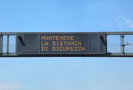 big traffic sign in high with text MANTENERE LA DISTANZA DI SICUREZZA that means keep the safety distance in italian Languageのeditorial素材
