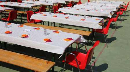 many tables set for a community lunch with many guestsの写真素材