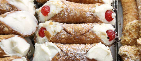 sicilian cannolo as a typical pastry in Southern Italy with red cherriesの写真素材