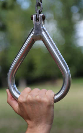 athlete's hand during workouts with steel ring in an outdoor gymの写真素材