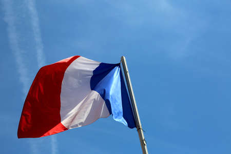 big french flag waves in the blue skyの写真素材