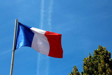 big french flag waves in the blue skyの写真素材