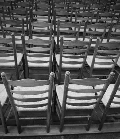 background so many wooden chairs in the place of worship with black and white effectの写真素材