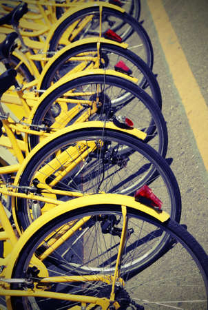 yellow bicycles for the bike rental system in the city called bike sharingの写真素材