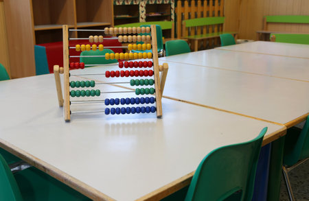 inside a classroom of kindergarten and an old wooden abacus on the tableの写真素材
