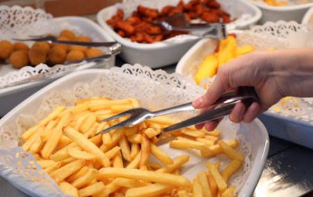 tray with many yellow hot fries in the self-service restaurant