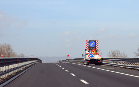 truck with big road sign with arrow on the motorway before the roadworks