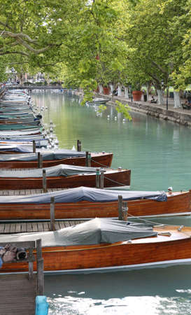 many moored boats in the navigable canal in Annecy City France in summerの写真素材