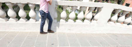 white balustrade of Ancient Bridge in Vicenza City in Italy and the legs of personの写真素材