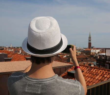 boy with a straw hat photographs the city of Venice from aboveの写真素材