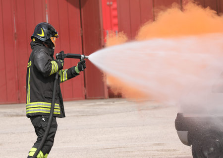 Rome, RM, Italy - May 23, 2019: fireman with helmet and foam during a fire drill