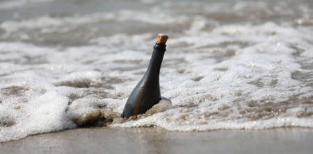 wavees of sea and a bottle of glass with a secret messageの写真素材