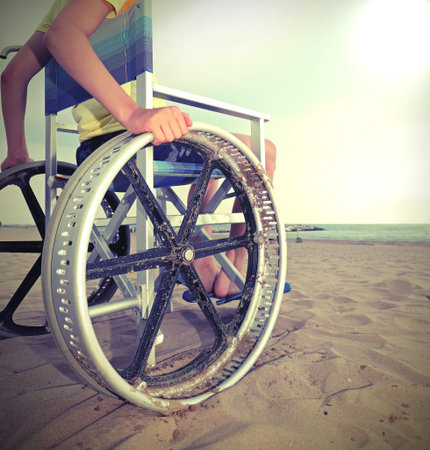 detail of a special wheelchair with very big wheels to move on the sandy beach of the resort with a...