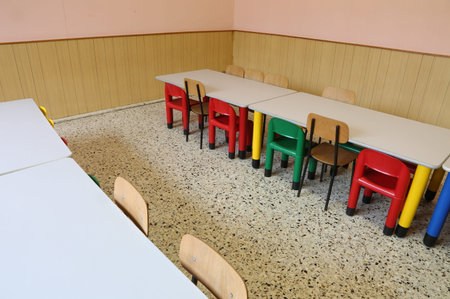 small chairs and long tables of a refectory of the nursery school without the children