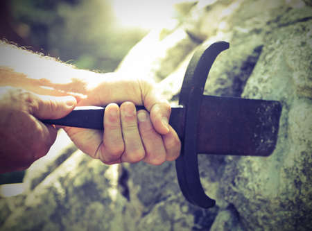 hand of knight and the sword in the stone called Excaliburの写真素材