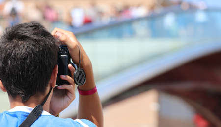 young Boy photographs the modern bridge called Ponte della Costituzione that means Constitution Bridge in Venice in Italy in summerの写真素材