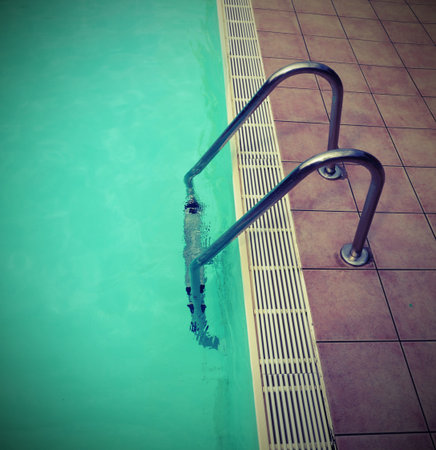 swimming pool and a stepladder without people in the resort with old toned effect