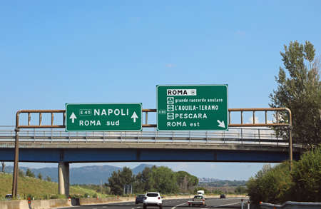 italian road sign on motorway near Rome City and the arrows directions to Naplesの写真素材