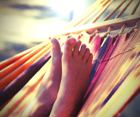 feet of girl on the hammock with old toned effectの写真素材