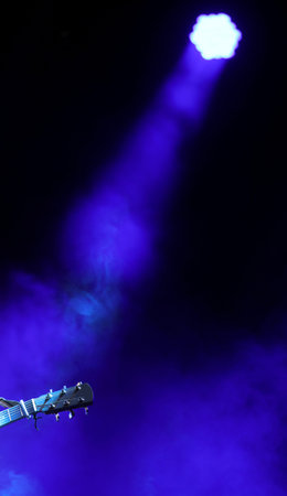 spotlight on the stage and the guitar with copy space to write some text
