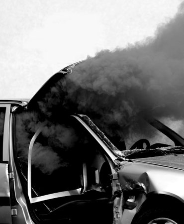 black dense smoke from a broken car after the accident