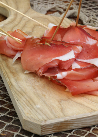typical italian red cold cuts with white fat on the wooden cutting boardの写真素材