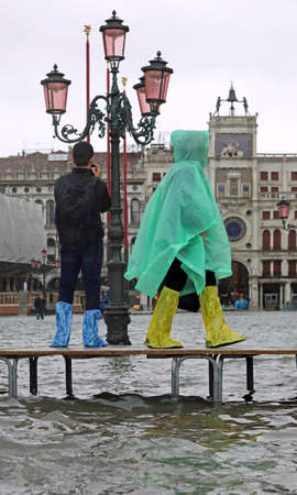 Pedestrian walkway with people with record high tide in Venice Italyの写真素材
