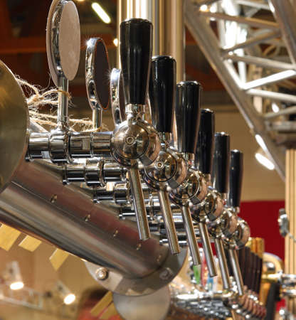 Many taps in stainless steel to draught beer in the pubの写真素材