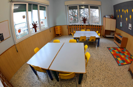 interior of a school class with low tables and small yellow chairs without children