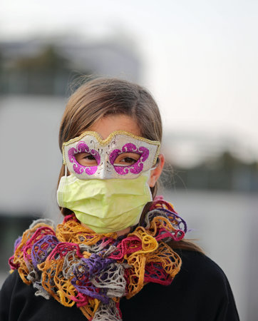 Young girl with health mask and carnival mask for protection against the Virus crown