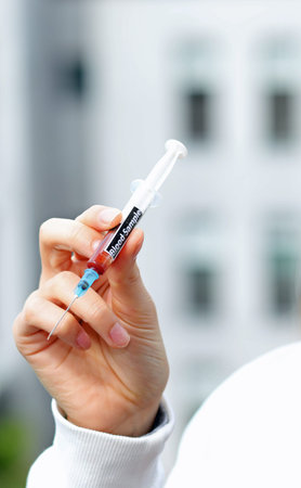hand od doctor with syringe containing a blood sample for analysis in the hospital laboratory