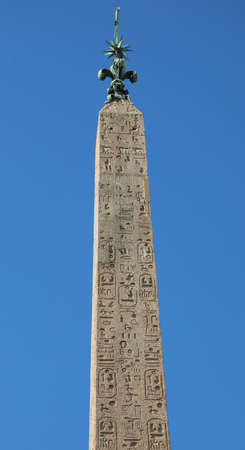 ancient egyptian obelisk with engraved hieroglyphics and blue sky on backgroundの写真素材