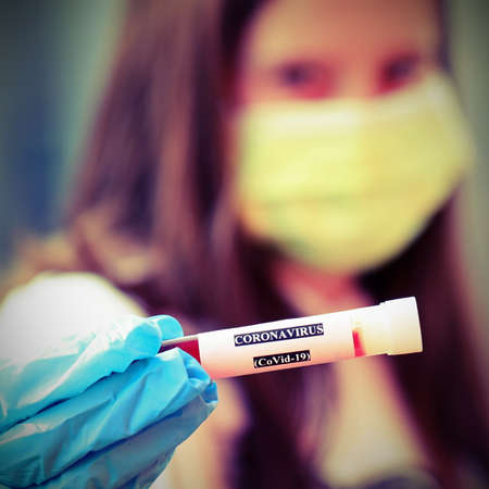 nurse wears surgical mask while working at the hospital and the sample with blood infected with Corona Virus and old toned effectの写真素材