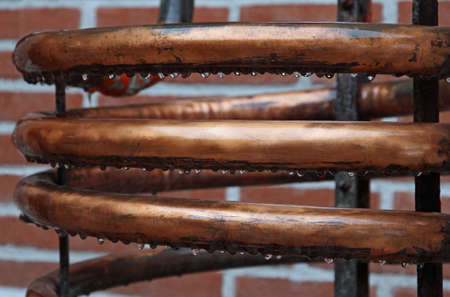 long wet copper coil for the distillation of spirits in a distilleryの写真素材