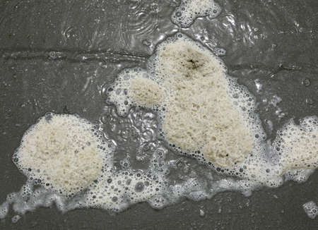 dense foam in the polluted water of the dirty sea due to industrial dischargesの写真素材