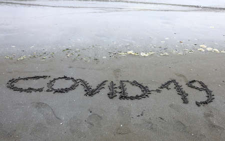 Text Covid-19 on the sand of the beach during the lockdownの写真素材