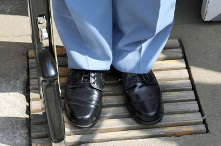 soldier uniform with shiny black shoes and rifle buttの写真素材