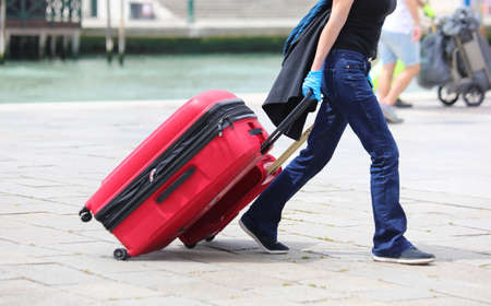 tourist in Venice with red suitcases while walkingの写真素材