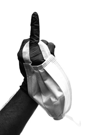 hand with surgical glove with middle finger raised as a sign of offense in sign language and...