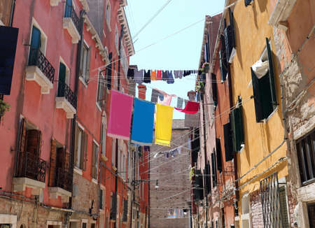 clothes hanging out to dry in a narrow Venice alley on a hot summer day without peopleの写真素材