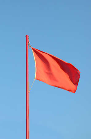 big red flag to signal the danger above the lookout towerの写真素材